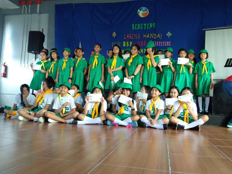 Girl Scouts and pupils in scouting uniform on stage