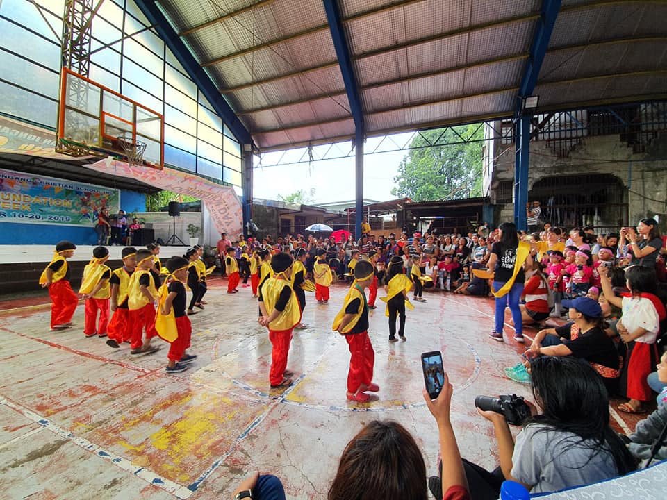 Pupils in red performing a Foundation Day dance